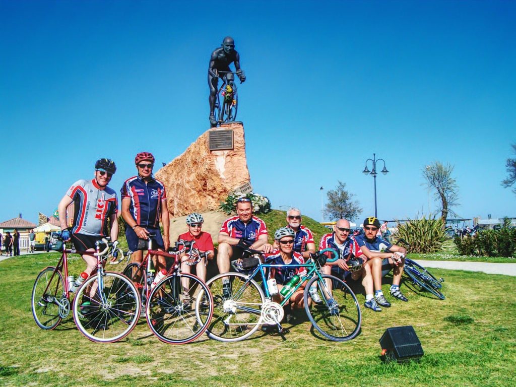 gruppo cicloamatori in posa davanti al monumento a pantani