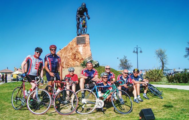 gruppo cicloamatori in posa davanti al monumento a pantani