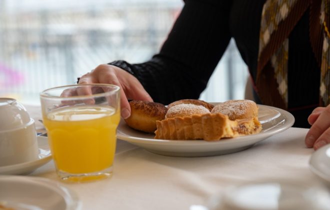 Colazione con succo d’arancia, crostata e bomboloncini
