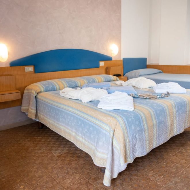 camera con letto matrimoniale e letto singolo con accappatoio e asciugamani sui letti camera con letto matrimoniale e letto singolo con accappatoio e asciugamani sui letti