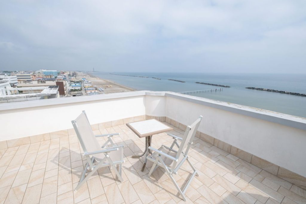sedie e tavolino sulla terrazza alta dell'hotel affacciato sul mare