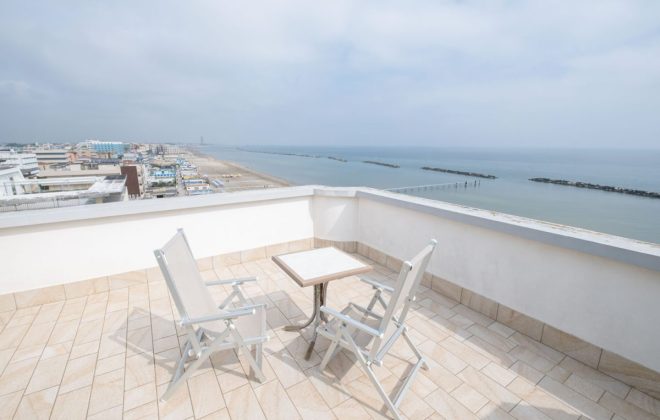 sedie e tavolino sulla terrazza alta dell’hotel affacciato sul mare