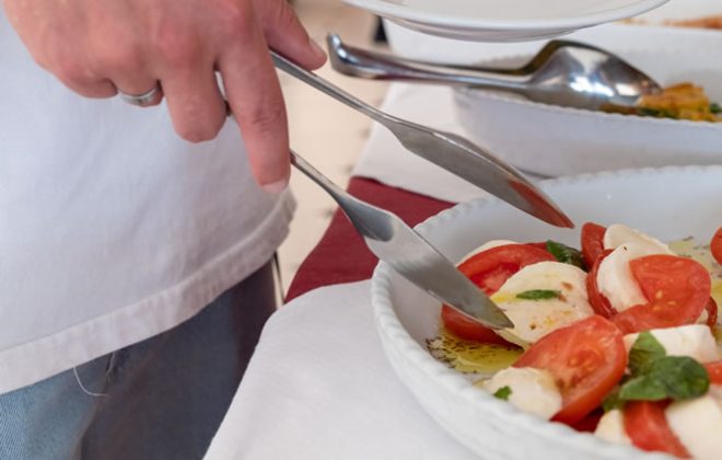 cliente si serve di insalata caprese dal buffet
