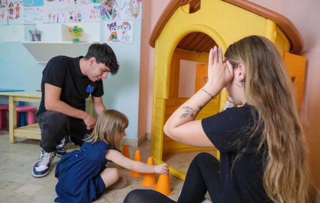 Bimba gioca insieme a due ragazzi dell’animazione