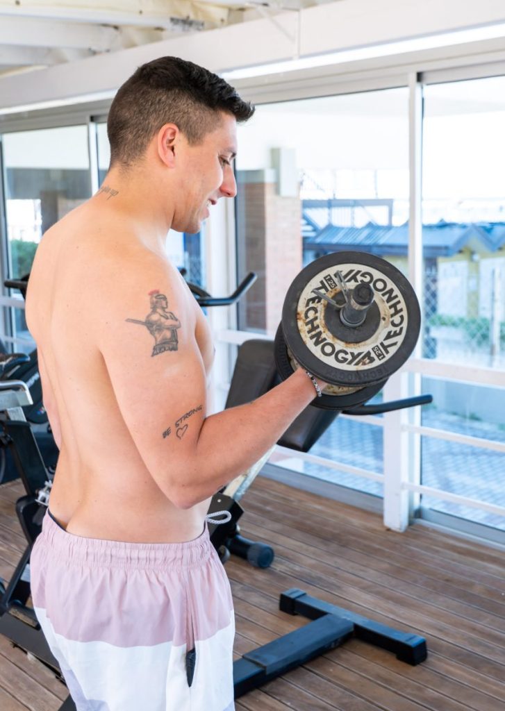 Sala fitness con cliente che fa i pesi